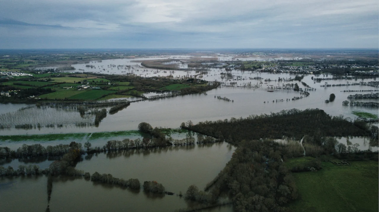 Vista aérea de uma planície alagada, com campos e árvores cobertos pela água